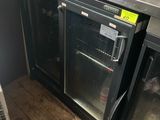 a refrigerator with a glass door in the middle of a kitchen