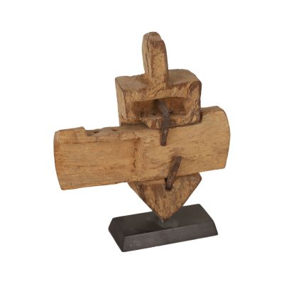 une sculpture en bois représentant une croix posée sur un socle