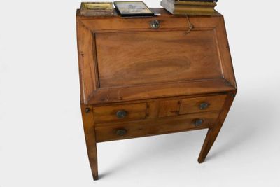 un petit bureau en bois sur lequel est posée une horloge