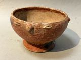 a small brown bowl sitting on top of a white table