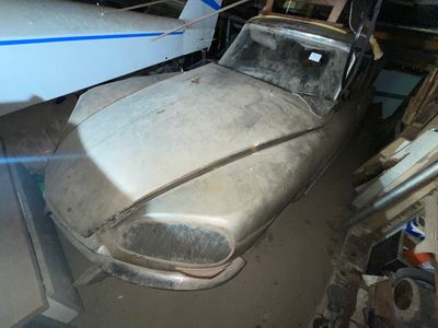 une voiture garée dans un garage à côté d'un avion