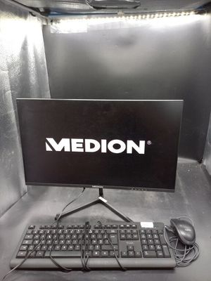un écran d'ordinateur et un clavier posés sur un bureau dans un box