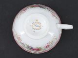 a cup and saucer on a table with a black background