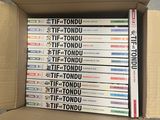 un grand nombre de DVD dans une boîte en carton posée sur le sol