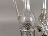 a silver plate with a glass vase and a mirror on it