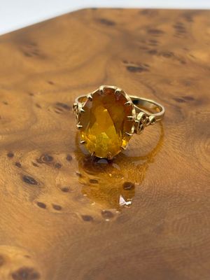 an image of a yellow ring sitting on top of a wooden table