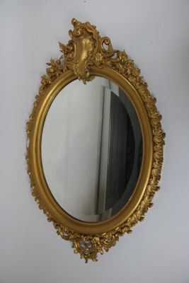 un miroir doré accroché au mur à côté d'une porte