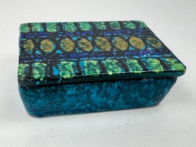 une boîte bleue et verte posée sur une surface blanche