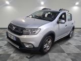 une photo d'une Dacia argentée garée sur un sol à damier