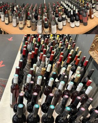 Des bouteilles de vin sont empilées sur une table dans un magasin de vins.