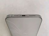 the back of a silver cell phone sitting on top of a white surface