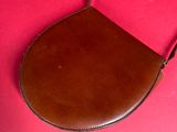 brown leather purse on a pink background