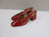pair of red shoes on a white surface with a white background