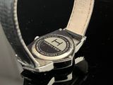 a close up of a watch on a black surface