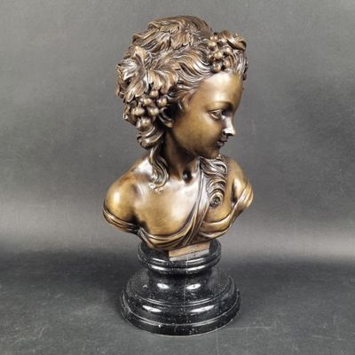 bronze bust of a woman with curly hair on a marble base