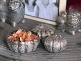 a bowl of dried flowers on a table next to a picture of a woman