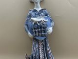 a figurine of a woman holding a basket of food