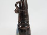 a brown and blue vase with a handle on a white table