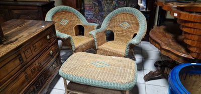 trois fauteuils en osier et un repose-pieds dans une pièce