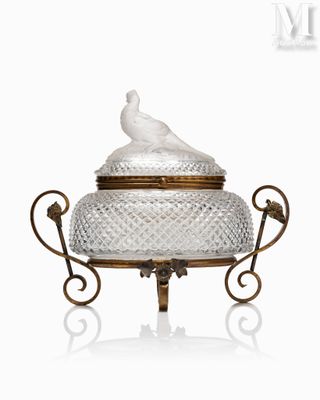 une image représentant un plat recouvert d'un couvercle en verre sur lequel figure un oiseau