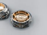 pair of silver and gold plated bowls on a gray surface