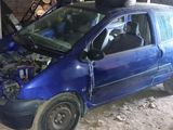 a small blue car with a broken hood in a garage