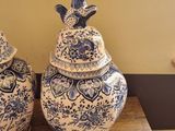 two blue and white vases sitting on a wooden table