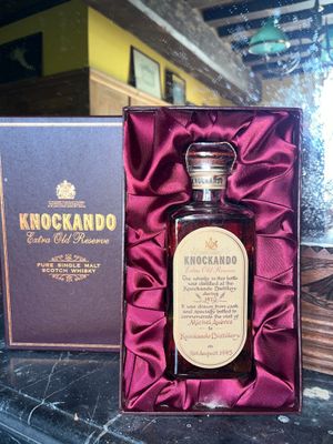 a bottle of liquor sitting in a box on a table