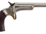 gros plan d'un pistolet avec une poignée en bois sur fond blanc