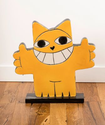 a yellow cat that is standing on a wooden stand