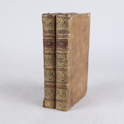 deux vieux livres posés l'un sur l'autre sur une surface blanche
