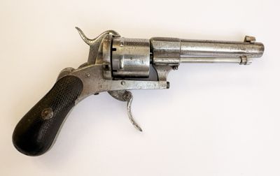 gros plan d'un revolver sur une surface blanche