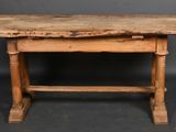 an old wooden table sitting on top of a black floor