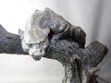 a statue of a bear on a tree branch
