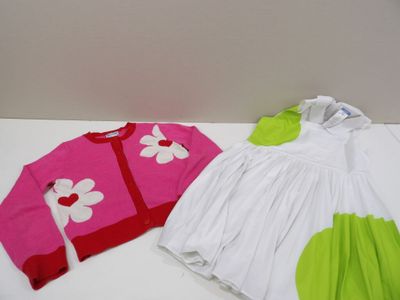 two dresses and a sweater on a white table