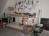 a workbench in a garage with tools on the wall