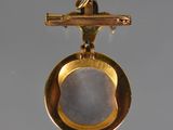 a close up of a gold plated object with a stone in the middle