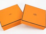 two orange boxes with black trims are open on a white surface