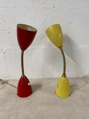 une paire de lampes de table rouges et jaunes posées sur une surface blanche
