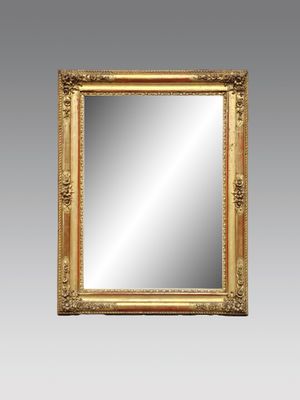 un miroir à cadre doré accroché à un mur gris