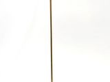 a gold floor lamp with a white shade on top of it