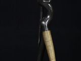 a black and gold statue of a woman with a vase on her head