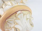 a close up of a figurine on a white surface