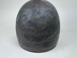 a black vase sitting on a table with a white background