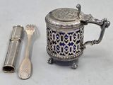 une théière en argent, avec une cuillère et un repose-cuillère à côté