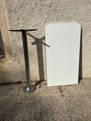 un tableau blanc appuyé contre un mur, à côté d'une table