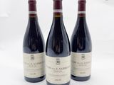 trois bouteilles de vin posées sur une table l'une à côté de l'autre