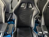 quatre sièges de course noirs et blancs posés sur un tapis bleu