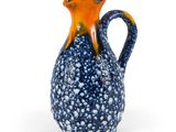 un vase orange et bleu orné de bulles, posé sur une surface blanche