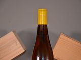 a bottle of wine sitting on a table next to a block of wood